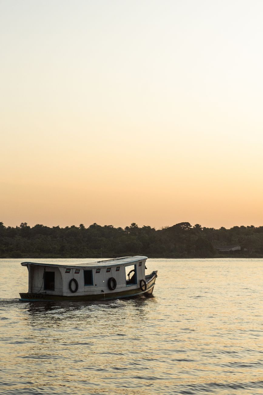 Barco no Rio Amazonas ao pôr do sol